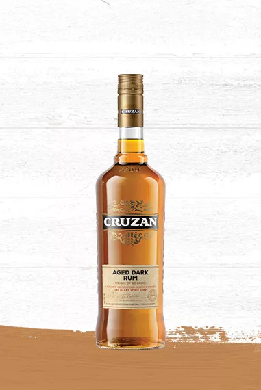 Cruzan Aged Dark Rum - Origin of St. Croix glass bottle set against a whitewashed wood background.