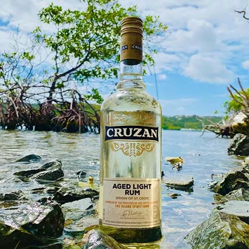 Image of Cruzan Aged Light Rum set atop the water in St. Croix.