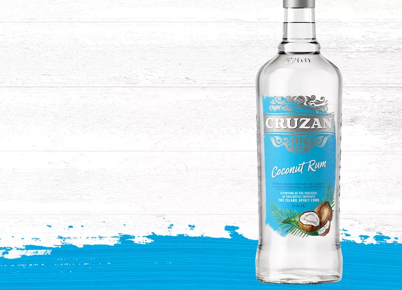 Cruzan Coconut Rum bottle against a whitewashed wood background with a blue paint swash.