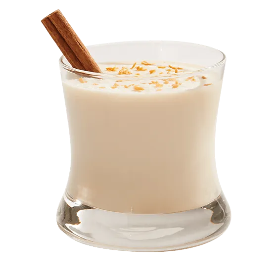 Coquito cocktail garnished with a cinnamon stick in a rocks glass.