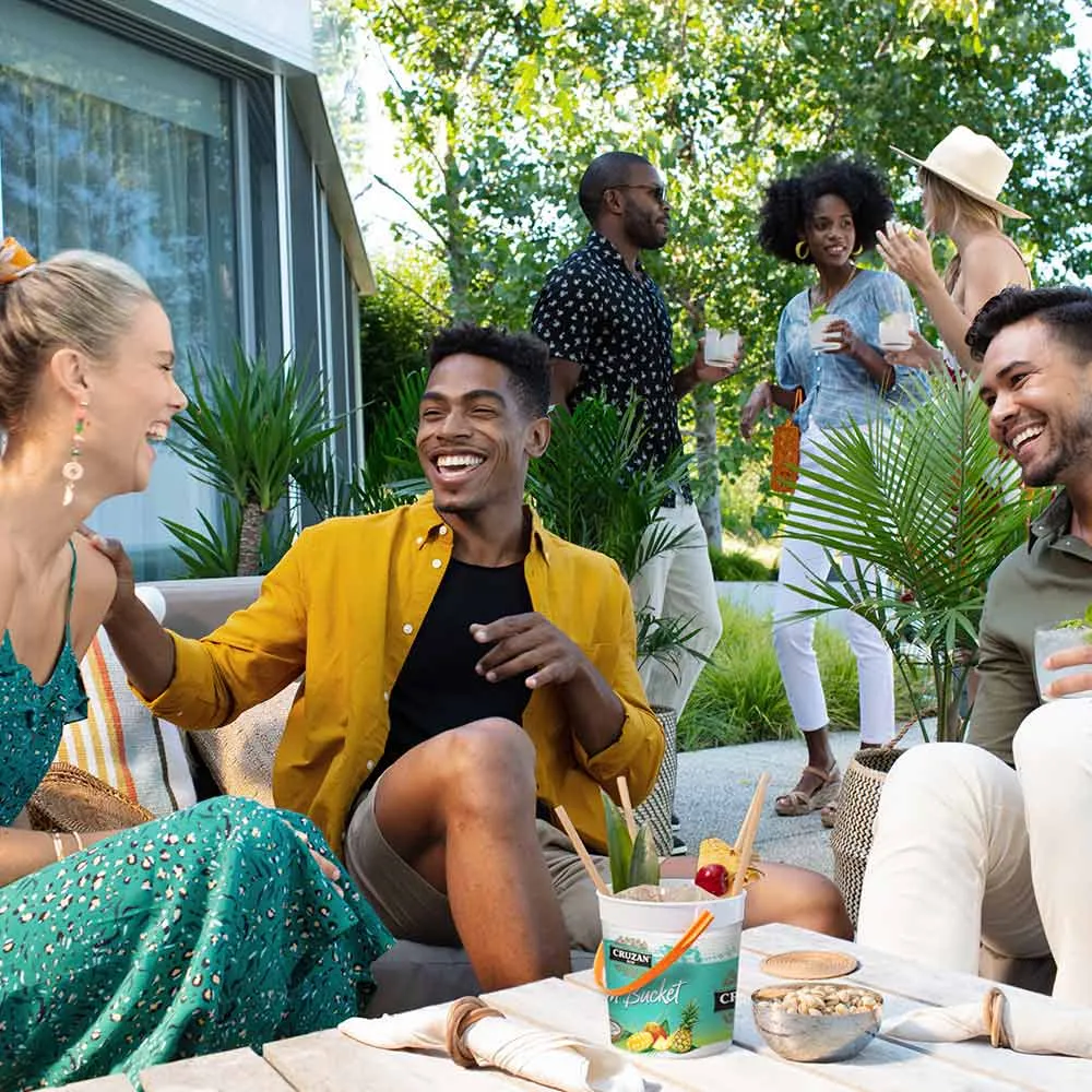 Group of friends enjoying a Rum Runner cocktail from the Cruzan® Rum bucket.