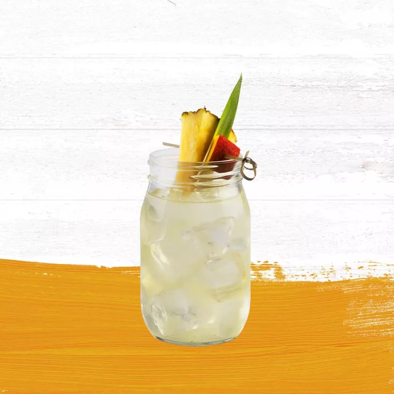 Cruzan® Confusion drink in a mason jar with a pineapple and mango garnish set against a whitewashed wood background with a mango hued paint swash.
