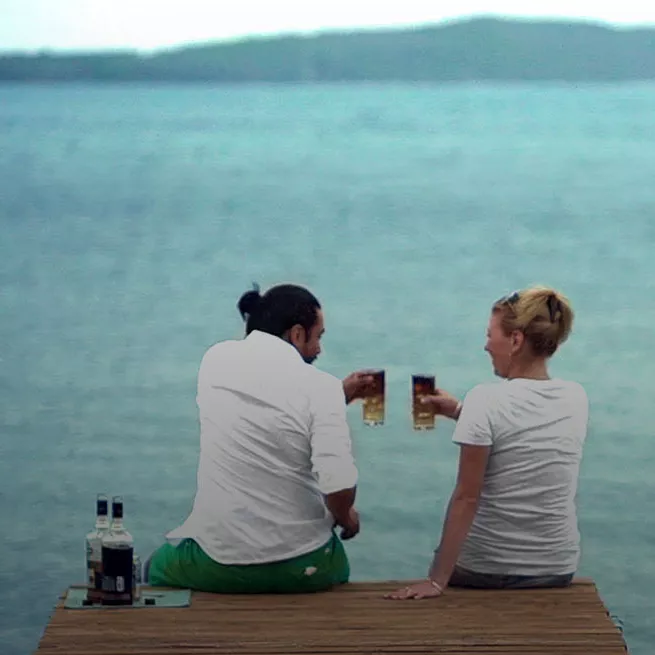 Image of a man and a woman on a dock with Cruzan mixed cocktails after a Cruzan distillery tour.