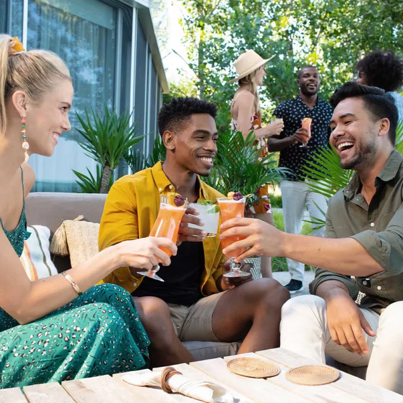Group of people enjoying a hurricane cocktail together outdoors.