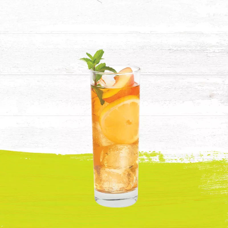 Cruzan® Citrus Rum and tea cocktail in a tall clear glass garnished with mint and peaches.