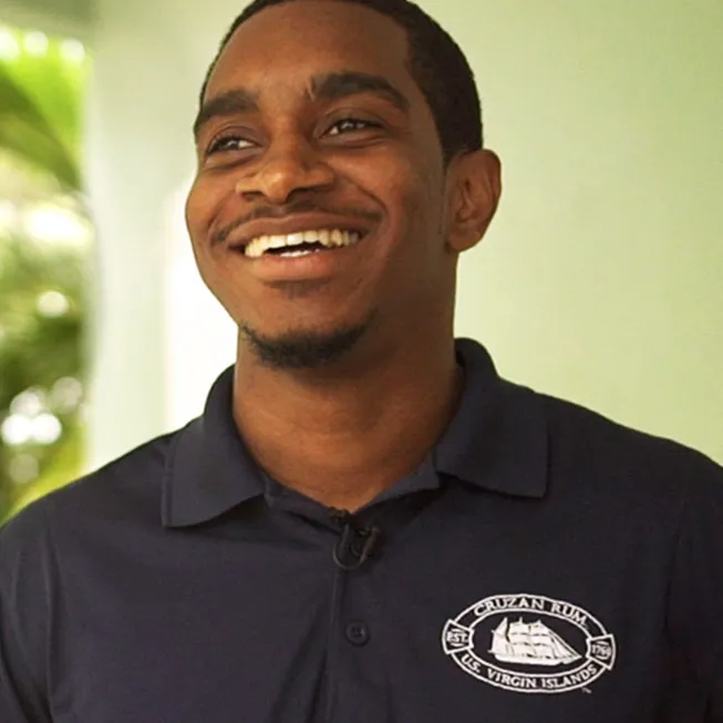 Cruzan Rum distillery employee smiling standing outside.