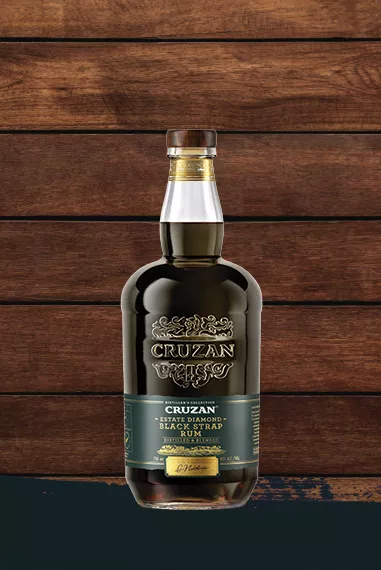 Cruzan Black Strap Rum in a clear bottle set against a dark oak wood background with a black paint swash.