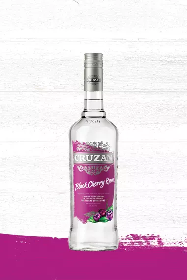 Cruzan Black Cherry Rum glass bottle set against a whitewashed wood background with a magenta paint swash.