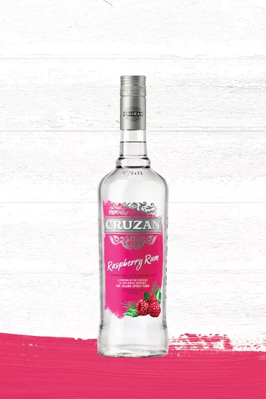 Cruzan Raspberry Rum clear bottle with a raspberry red label set against a whitewashed wood background with a raspberry red paint swash.