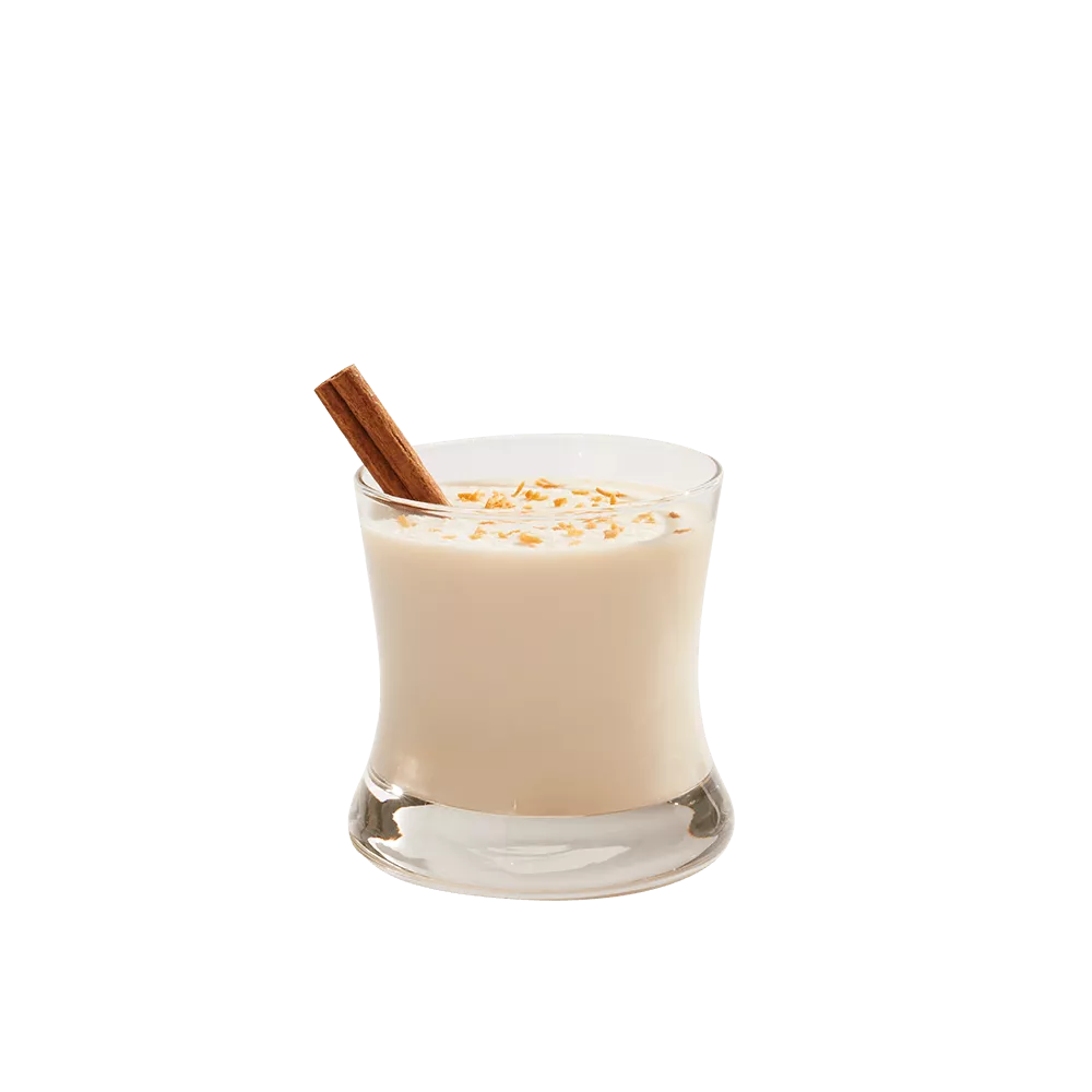 Coquito cocktail garnished with a cinnamon stick in a rocks glass.