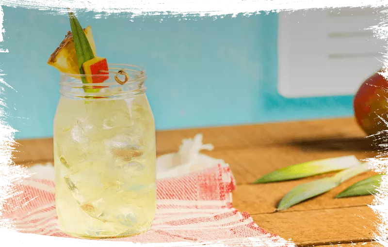Cruzan® Confusion rum cocktail in a mason jar set on a red and white towel against a tropical background.
