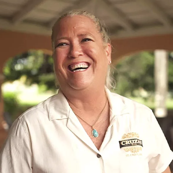 Photo of Karen Nelthropp in a cream Cruzan Rum distillery blouse.