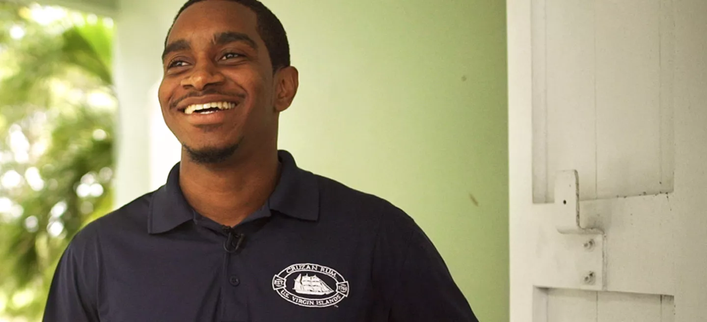 Cruzan Rum distillery employee smiling standing outside.